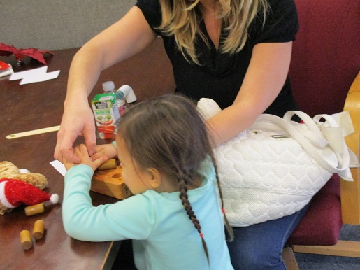 A mother and her blind child doing Braille